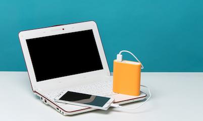 A laptop and a smartphone connected to a portable battery or power bank