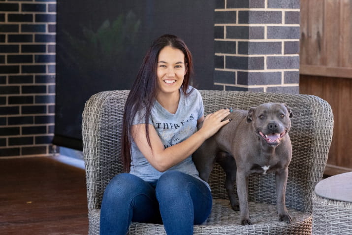 Open Universities Australia student Taylah sitting with her English staffy dog.