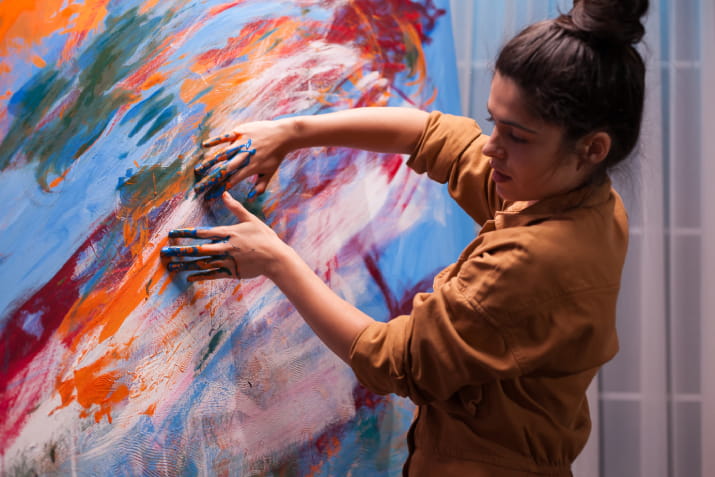 An artist running her hands over a painting