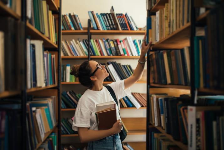 A young woman browsing books on a shelf