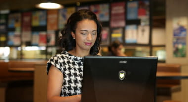 Open Universities Australia student, Kelly, working on a laptop computer.